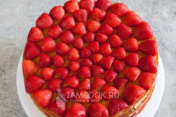 Положить на бисквит клубнику