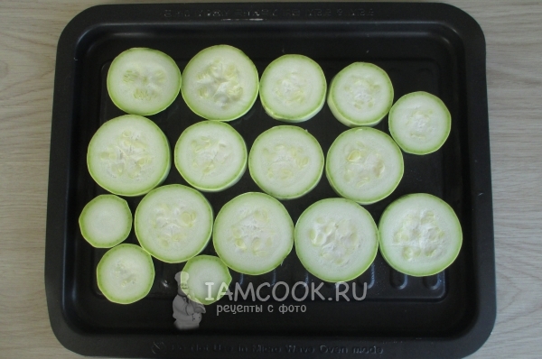 Выложить на противень кабачки