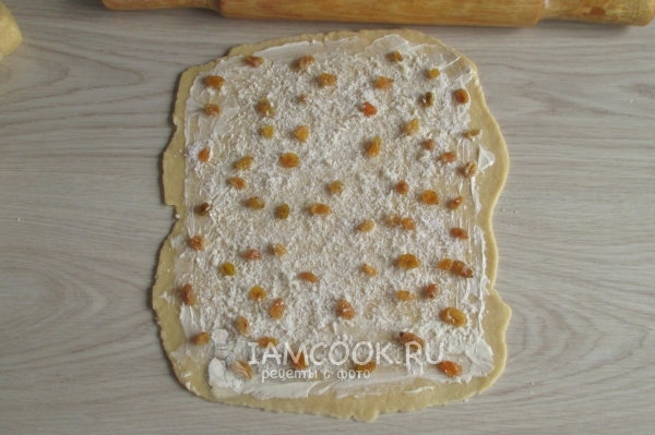 Положить на тесто изюм