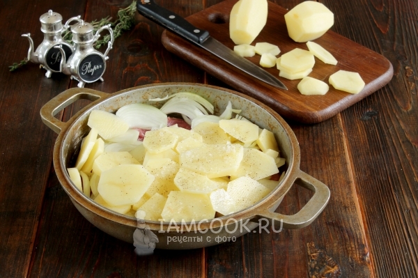Положить на мясо лук и картофель