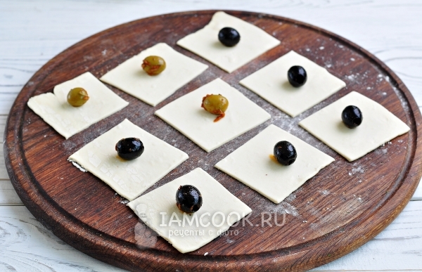 Положить на тесто маслину