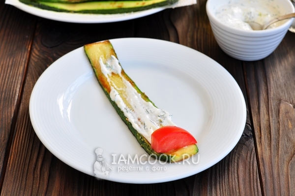 Положить на кабачок соус и помидор