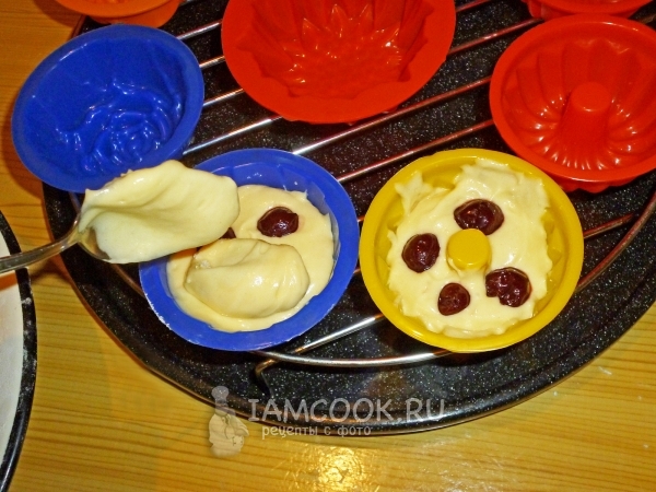 Положить в формочки тесто и вишню