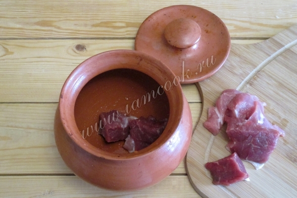 В горшочки положить мясо