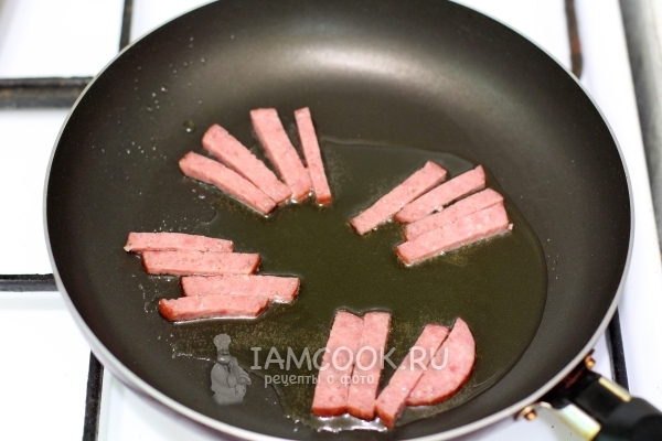 Положить колбасу на сковороду