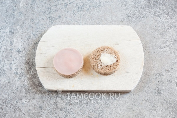 Положить на хлеб масло и колбасу