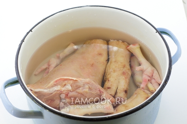 Положить куриные и свиные ножки в кастрюлю с водой