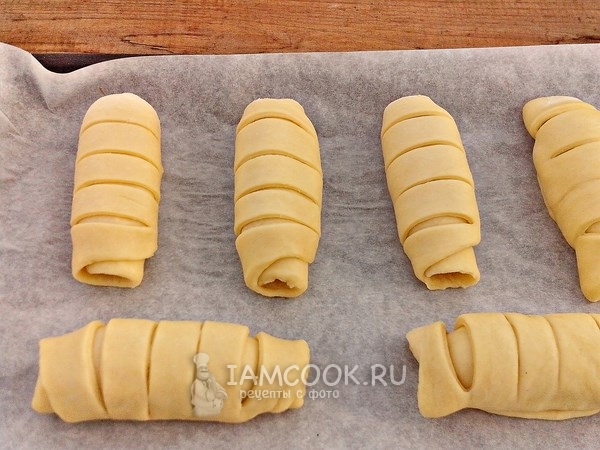 Положить сосиски в тесте на противень