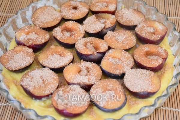 Выложить на тесто сливы с сахаром