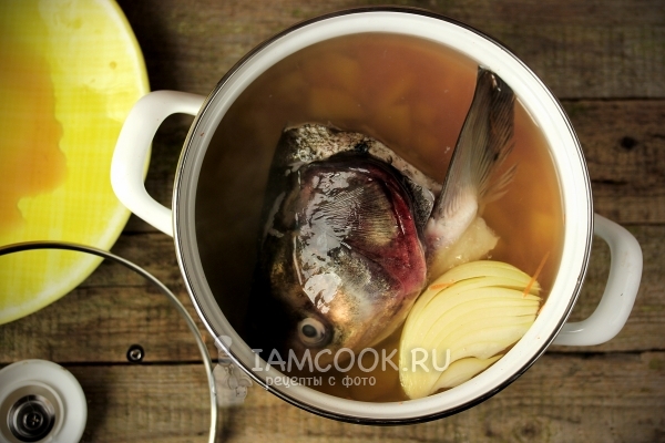 Положить в кастрюлю голову рыбы и овощи