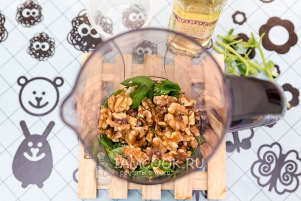 Положить в блендер базилик, чеснок и орехи