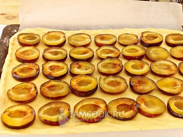 Выложить на тесто сливы