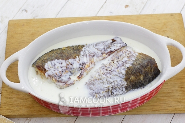 Положить рыбу в форму со сметанной заливкой