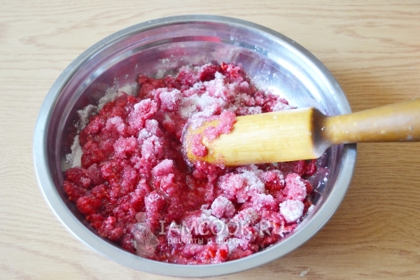 Размять сахар с малиной