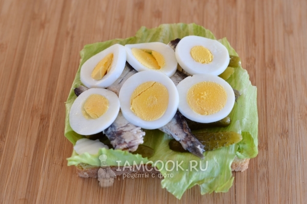 Положить нарезанные яйца