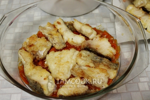 Положить рыбу на слой лука и моркови