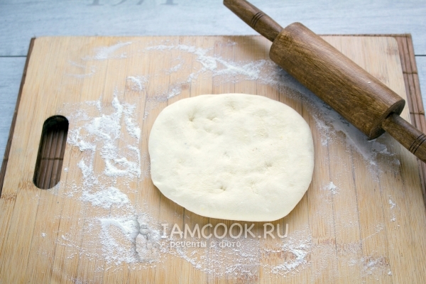 Переложить тесто на доску с мукой