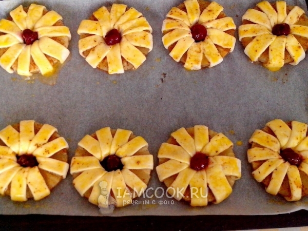 Переложить слойки на противень и смазать яйцом