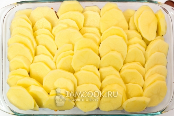 Выложить в форму лук, морковь, мясо и картофель