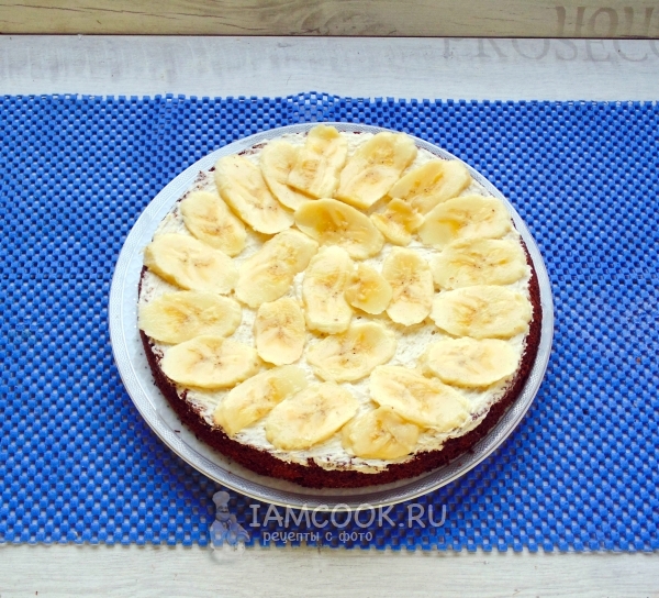 Положить на корж крем и кусочки банана