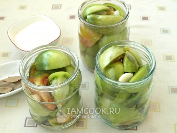 Уложить помидоры и чеснок в банки