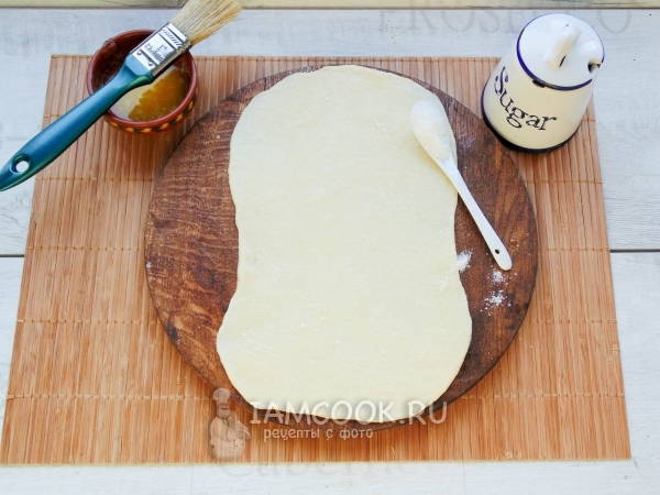 Тесто смазать масло и посыпать сахаром