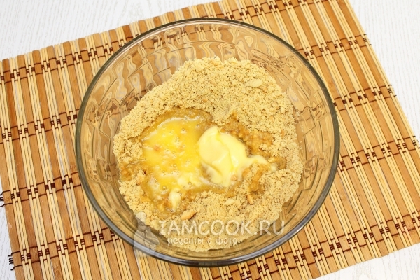 Смешать измельченное печенье с маслом