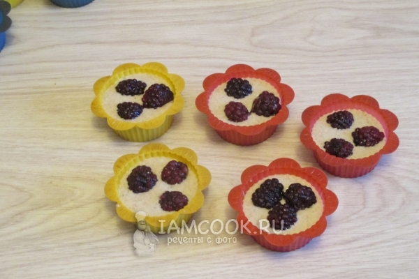 Положить в формочки тесто и ягоды