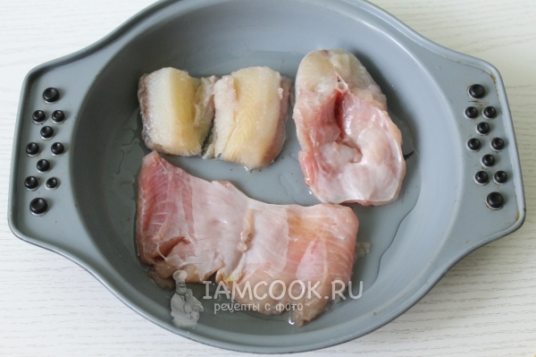 Положить кусочки рыбы в форму с маслом