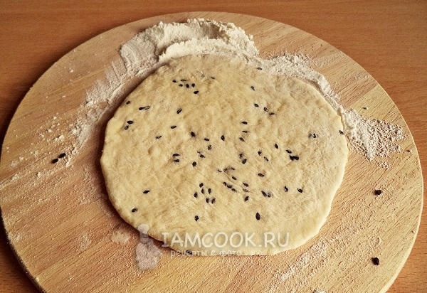 Раскатать лепешку и посыпать кунжутом