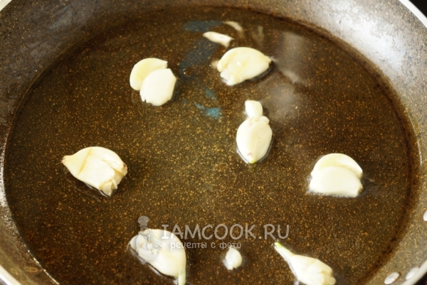 Положить чеснок на сковороду с маслом