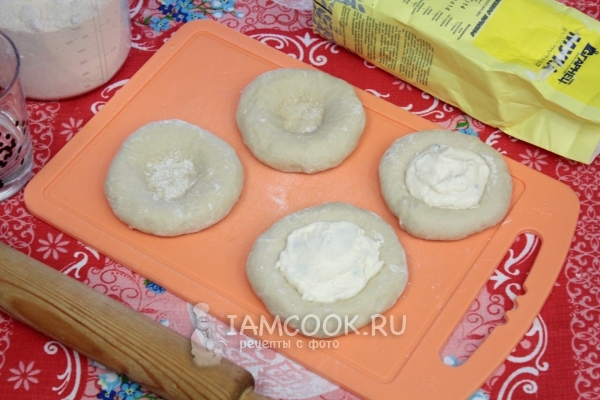 Положить на тесто творог