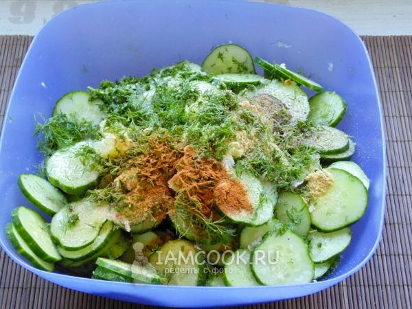 Смешать огурцы с зеленью, чесноком и специями