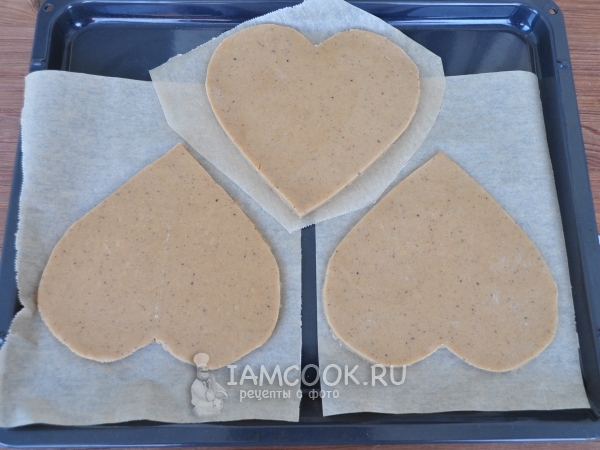 Положить сердечки из теста на противень