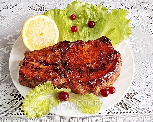 Готовый стейк из свинины на кости в сковороде