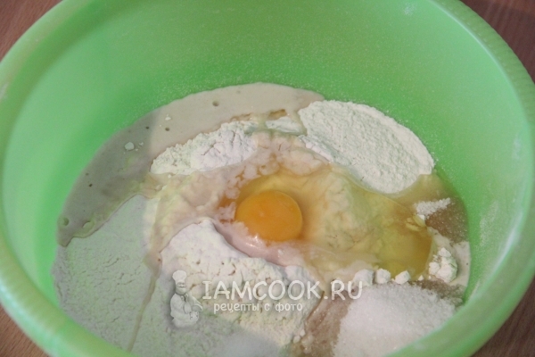 Положить в миску муку, яйцо и дрожжи