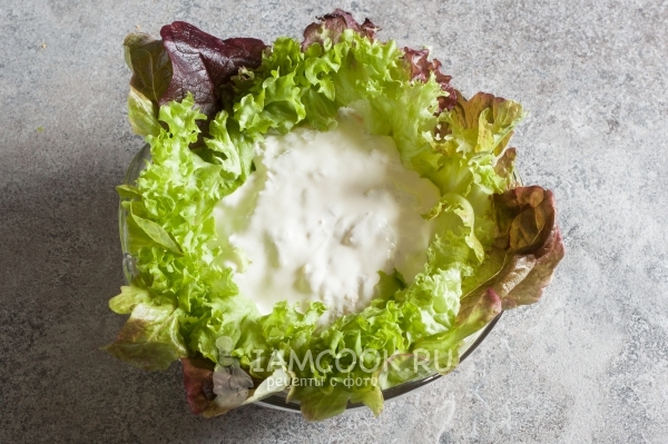 Уложить по краям блюда листья салата
