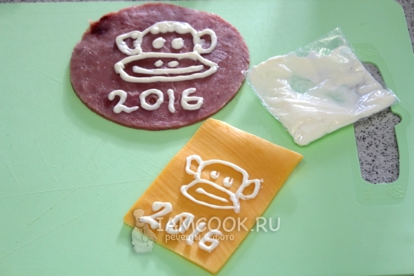 Нарисовать на сыре майонезом мордочку обезьянки
