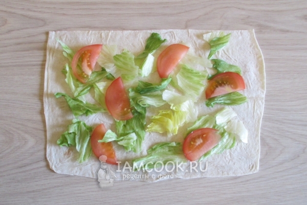 Положить на лаваш листья салата и помидор