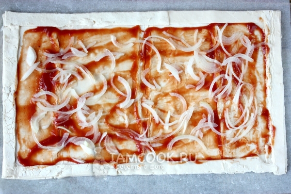 Смазать томатным соусом и положить лук