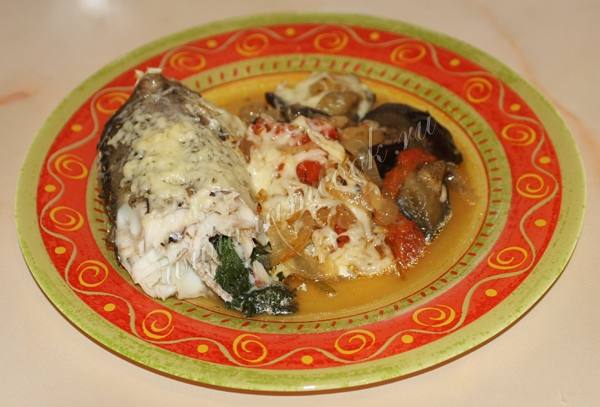 Пикша запеченная с овощами на тарелке, фото