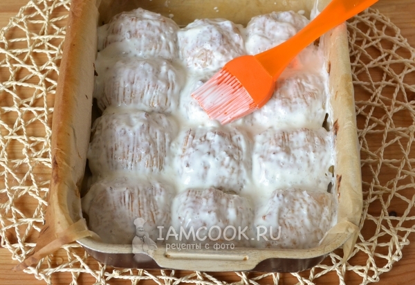 Смазать тефтели сметаной с чесноком