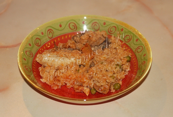 Плов с курицей и свининой в тарелке