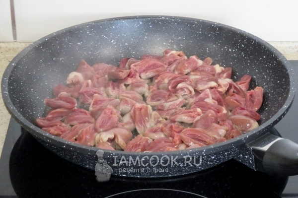 Положить куриные сердечки в сковороду