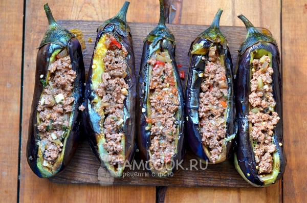 Выложить овощи с фаршем в баклажаны
