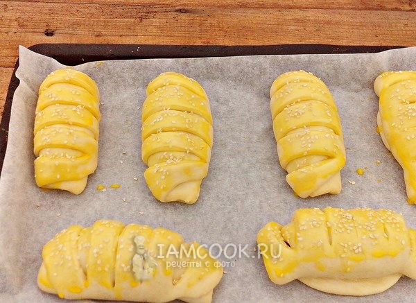 Смазать яйцом и посыпать кунжутом