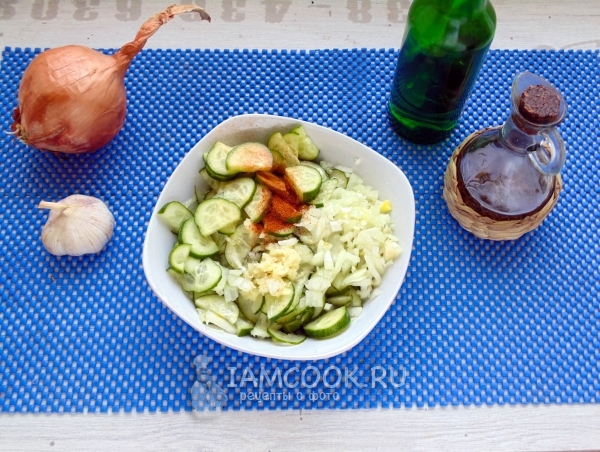 Смешать огурцы, лук с чесноком и специи