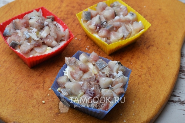 Выложить слой яиц и рыбы