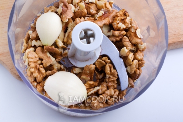 Положить в блендер орехи и чеснок