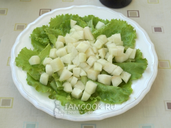 Выложить на листья салата грушу